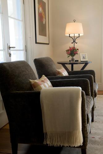 a living room with two chairs and a lamp at Villa Talia Tasmania in Wattle Grove