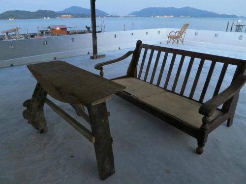 a wooden bench with a table on top of a building at Pangkor Fish House in Pangkor