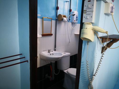a bathroom with a phone next to a sink at Pangkor Fish House in Pangkor