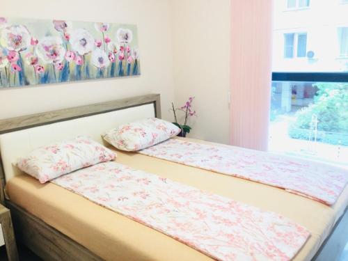 a bed with two pillows on it in a room at Апартамент Франческа in Varna City