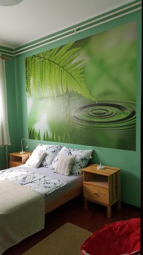 een slaapkamer met een bed met een groene muur bij Apartment Comeback in Zagreb