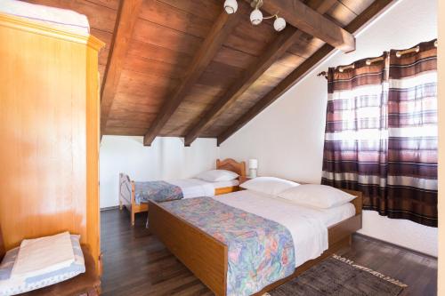 a bedroom with two beds and a wooden ceiling at Apartment Tia - by TA Leut Agency in Privlaka