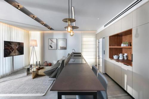 a dining room with a long table and chairs at Beach Lux Apartment in Haifa