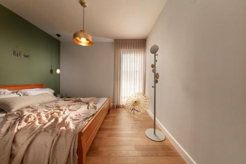 a bedroom with a large bed and a floor fan at Beach Lux Apartment in Haifa