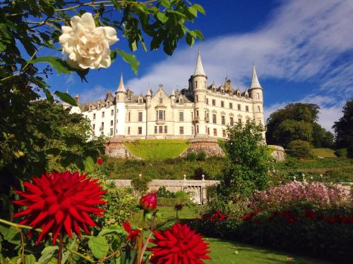 a large castle with flowers in front of it at Song of the Sea, Selkie House in Helmsdale