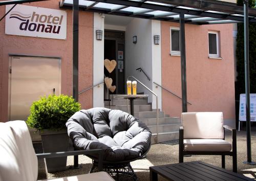 
a man sitting on a couch in front of a coffee shop at Hotel Donau in Donauwörth
