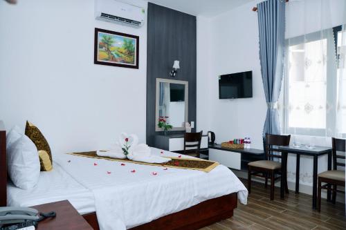 a hotel room with a large bed and a table at Buon Ma Thuot Hotel in Buon Ma Thuot