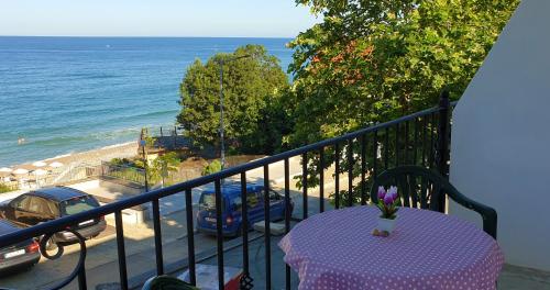 a table on a balcony with a view of the ocean at Майстор Костадин - 1878 in Obzor