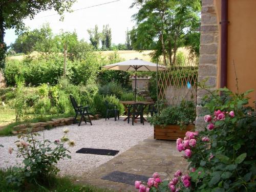 une terrasse avec une table, des chaises et un parasol dans l'établissement Casa dei ciliegi, à San Lorenzo in Campo