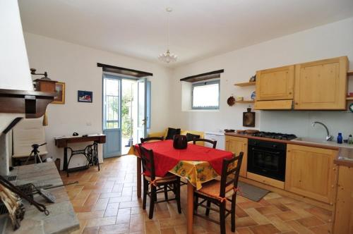 a kitchen with a table with a red table cloth at Casa dei ciliegi in San Lorenzo in Campo