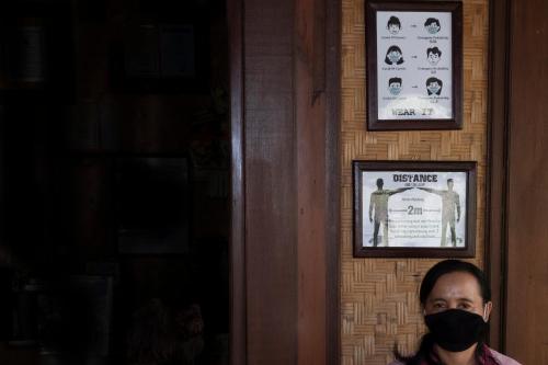 a man wearing a mask in front of a wall at Murni's Houses & Spa in Ubud