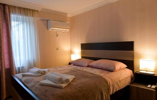 a hotel room with a bed with towels on it at Cozy House in Kutaisi