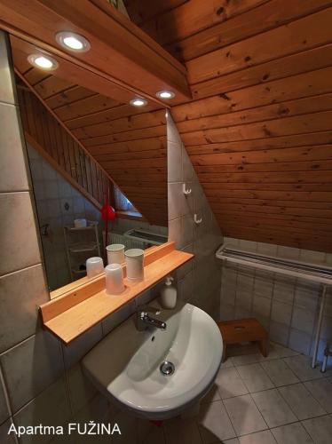 a bathroom with a sink and a wooden ceiling at Apartments Cesar in Bohinj