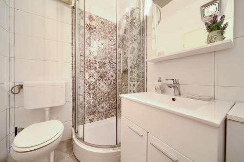a bathroom with a toilet and a shower and a sink at Apartments Dubravka in Krk