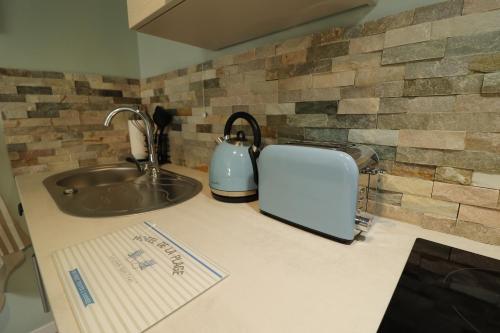 a kitchen counter with a sink and a toaster at Les Platanes in Saint Lo