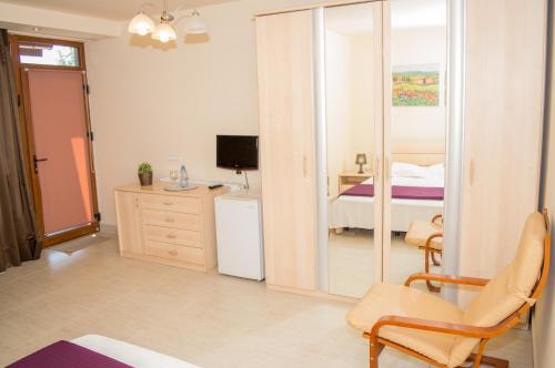 a room with a bedroom with a bed and a mirror at Casa Hortensia in Mangalia