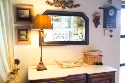 lámpara sobre una mesa en una habitación con espejo en Villa Evdora, en Alyki