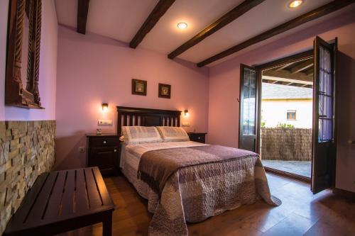 a bedroom with a bed and a bench in it at Apartamentos Rurales Casa Pachona in Puerto de Vega