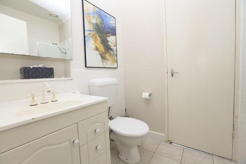 a white bathroom with a toilet and a shower at Downstairs in Hawthorn in Melbourne