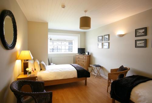 Schlafzimmer mit einem Bett, einem Schreibtisch und einem Fenster in der Unterkunft Margaret's Cottage B&B in Ardglass