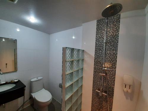 y baño con aseo, lavabo y ducha. en Amin Resort, en Bang Tao Beach