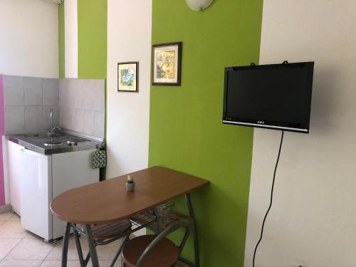 une cuisine avec une table et une télévision murale dans l'établissement Family Stakic, à Baška Voda