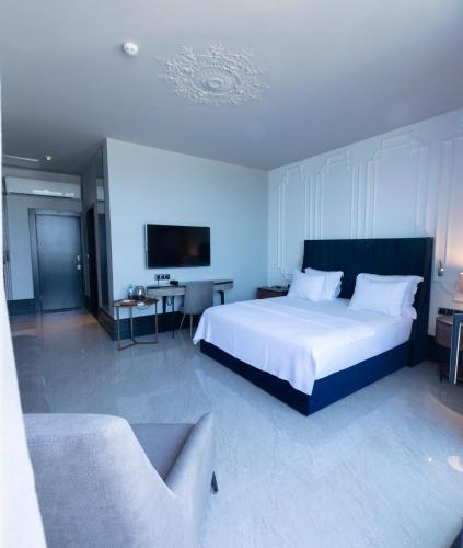 a bedroom with a large white bed and a couch at Venn Boutique Hotel in Samsun
