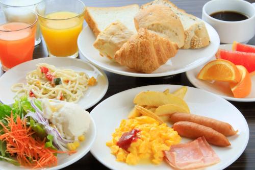 a table with plates of breakfast foods and drinks at Daiwa Roynet Hotel Tokyo Akabane in Tokyo