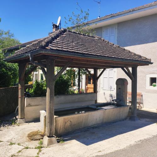 a wooden gazebo in front of a house at La Source d'Arbère in Divonne-les-Bains