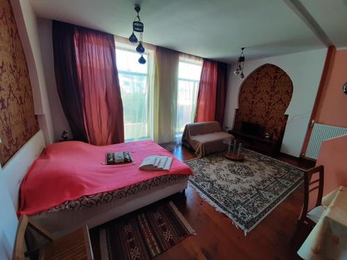 a bedroom with a red bed and a chair at Гостевой дом in Chornomorsk