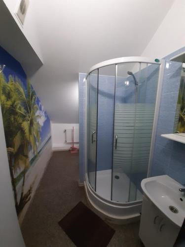 a bathroom with a glass shower and a sink at Гостевой дом in Chornomorsk