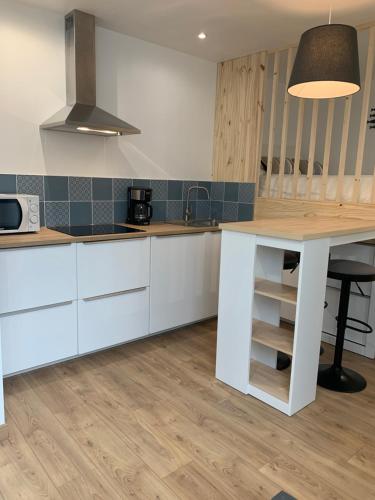 une cuisine avec des armoires blanches et un comptoir dans l'établissement Studio Guiriden, à Fouesnant