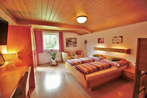 um quarto com uma cama e um tecto de madeira em Appartement Ripper em Saalbach-Hinterglemm