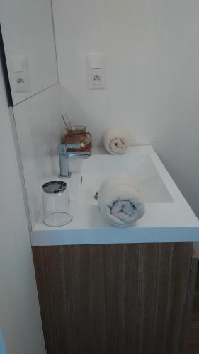 - un comptoir de salle de bains avec un lavabo et 2 serviettes dans l'établissement Chambre et petit déjeuner près de la mer, à Saint-Pair-sur-Mer