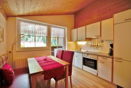 une cuisine avec une table et une fenêtre. dans l'établissement Appartement Ripper, à Saalbach-Hinterglemm