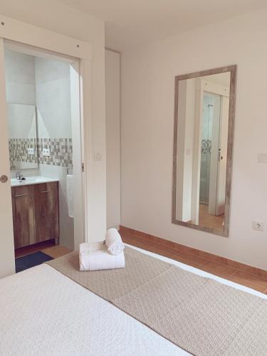 a bathroom with a white bed and a mirror at Pensión San Antón in Sanxenxo