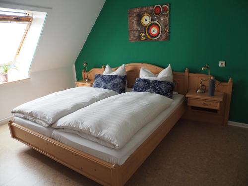 ein Schlafzimmer mit einem großen Bett und einer grünen Wand in der Unterkunft Ferienhof Meyer in Nahrendorf