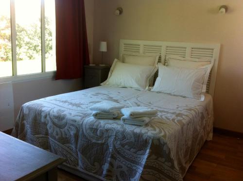 1 dormitorio con 1 cama con toallas en Chambres d'hote le Prelude en Saint-Martin-des-Noyers