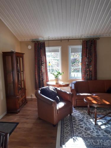 a living room with two leather couches and a table at The Cottage Badelunda in Västerås