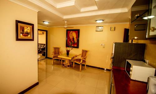 a living room with a table and chairs in it at Urban Rose Hotel & Apartments in Dar es Salaam