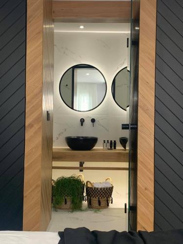 a bathroom with a sink and a mirror at Hotel Palatia in Naxos Chora