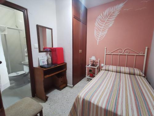 a bedroom with a bed and a sink and a mirror at Hostal Senero in Merida