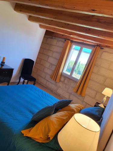 une chambre avec un lit bleu et une fenêtre dans l'établissement Le Mas de Paulette, à Mézoargues