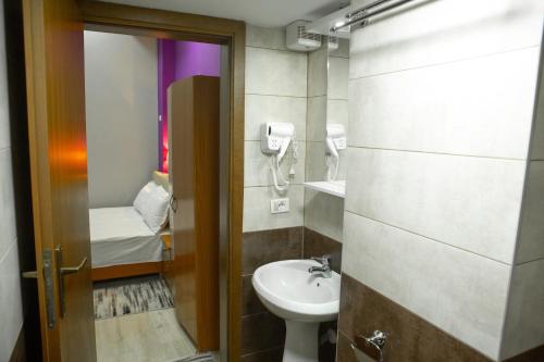 łazienka z toaletą i umywalką w obiekcie Vila Korani w Tiranie