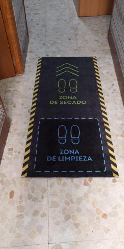 a black rug on the floor in a room at Hostal Senero in Merida