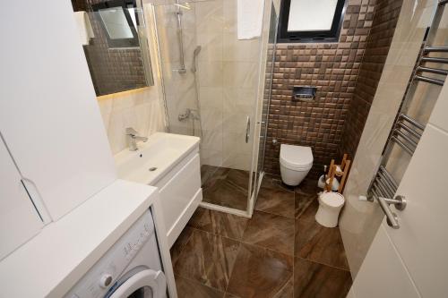a bathroom with a shower and a sink and a toilet at Saatli Suites in Cesme