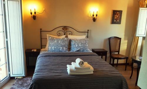 a bedroom with a bed with a towel on it at CASA DO CASTELLO MONSANTO in Monsanto
