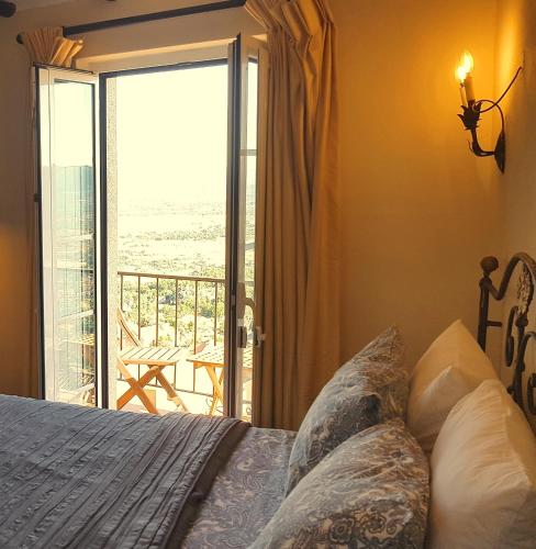 a bedroom with a bed and a view of a balcony at CASA DO CASTELLO MONSANTO in Monsanto