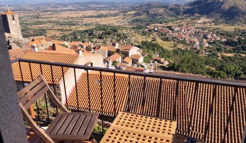 a balcony with a chair and a view of a town at CASA DO CASTELLO MONSANTO in Monsanto