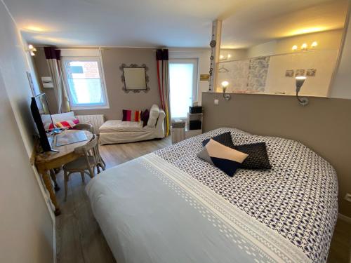 een slaapkamer met een bed en een tafel en een kamer bij Studio rez-de-chaussée, à Lesquin/Lille aéroport in Lesquin